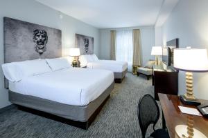a hotel room with two beds and a desk at Crowne Plaza New Orleans French Qtr - Astor by IHG in New Orleans