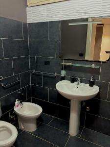 a bathroom with a sink and a toilet and a mirror at La Suite Onda Salentina in Carpignano Salentino