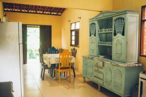 a kitchen with a table and a green cabinet at Chill House Pipa in Pipa