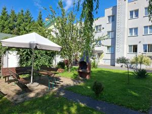 a picnic table and an umbrella in a yard at HORTENSJA 100 in Koszalin