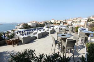 a rooftop patio with tables and chairs and the ocean at Le Rhul in Marseille