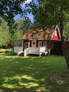 TrensumForrest cottage by the lake的红色的房子,有红色的屋顶和院子 更多9张照片