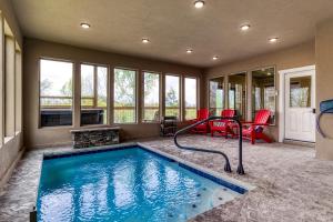 セバービルにあるAdventure Splash - Smoky Mountain Retreats Cabins with Private Indoor Pool, Hot Tubs & Fun!の赤い椅子付きの家のスイミングプール