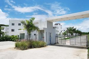 a white building with a palm tree in front of it at Peace Place in Santiago de los Caballeros