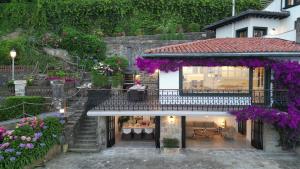 a house with a garden with purple flowers at VILLA EMBIL GETARIA in Getaria