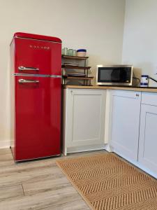 een rode koelkast in een keuken met een magnetron bij Modern apartment overlooking a Historic Downtown in Elloree
