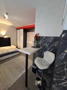 a room with a desk and a bed and a table at HORTENSJA 100 in Koszalin