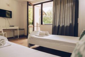 a hotel room with two beds and a window at Wildwood Villa in Apriltsi +27 photos