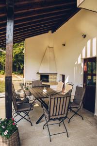 a table and chairs on a patio with a fireplace at Wildwood Villa in Apriltsi