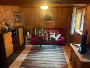 a living room with a red couch and a table at Traditionelles Haus in Trieben