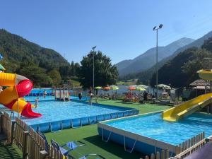 a water park with two pools with slides and people at Suite Romantica Fuga in Roncone