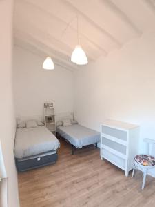 a bedroom with two beds and a dresser and a table at La placita in Zaragoza