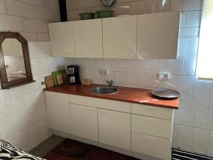 a kitchen with white cabinets and a sink at Simpel overnachten in Langeveen