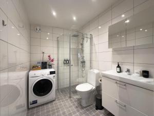 a bathroom with a toilet and a washing machine at Prinshöjden Apartments & Villas - Katrineholm Residential in Katrineholm +35 photos