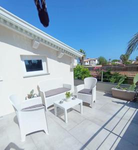 サンタ・マリア・デル・フォカッロにあるVilla LORY SWEET ORCHIDEAのパティオ(白い椅子、テーブル付)