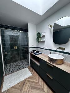Moustoir-AcにあるModern Britain homeの洗面台と鏡付きのシャワーを備えたバスルーム +27枚の写真