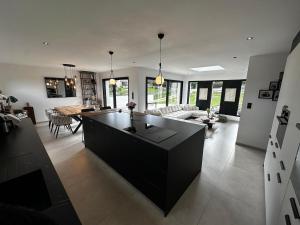 Moustoir-AcにあるModern Britain homeの黒いアイランドのある広いキッチンとリビングルーム