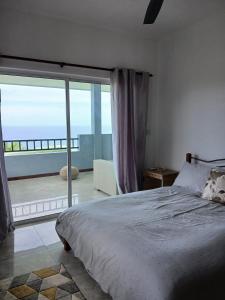 a bedroom with a bed and a view of the ocean at Royale Green Villa in Anse Royale