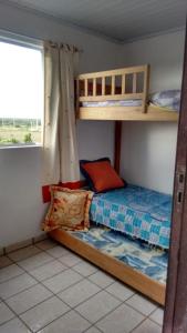 a bedroom with two bunk beds and a window at Pé na areia in Ilha Comprida