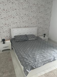a bed in a room with a brick wall at Garsoniera Mtk in Turnu Măgurele