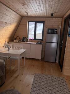 Una cocina con refrigerador y una mesa en una habitación. en Paradise, en Ach'khoti