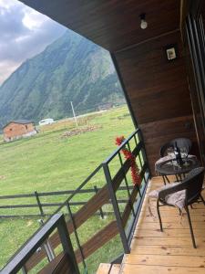 Un balcón de una casa con una mesa y sillas. en Paradise, en Ach'khoti