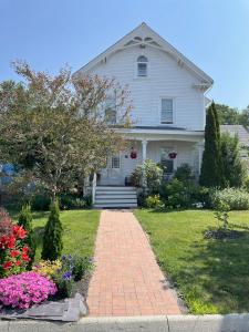 a white house with a brick walkway in the yard at Falls Farmstead 1865 Ellis House - Apt 3 in Ellsworth