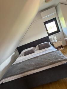 a bedroom with a large bed with a window at Small Hill Heaven in Varaždin Breg