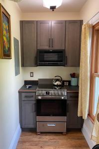 a kitchen with a stove and a microwave at Falls Farmstead 1865 Ellis House - Apt 3 in Ellsworth