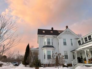 a white house with snow on the ground at Falls Farmstead 1865 Ellis House - Apt 3 in Ellsworth
