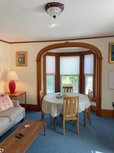 a living room with a table and a couch at Falls Farmstead 1865 Ellis House - Apt 3 in Ellsworth
