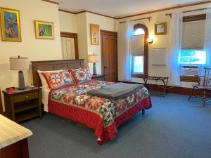 a bedroom with a bed and a table and chairs at Falls Farmstead 1865 Ellis House - Apt 3 in Ellsworth +11 photos
