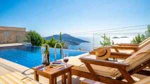 a villa with a swimming pool and a table with wine glasses at Eco Villa BEGONVİL in Kalkan