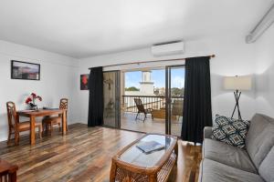 una sala de estar con un sofá y una mesa en Kona Plaza#414, en Kailua-Kona
