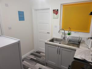 a kitchen with a sink and a white door at The Hill Flat in Stanley