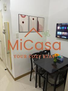 a dining room with a table and a sign on the wall at MiCasa South Residences Cozy & Affordable Stay in Manila
