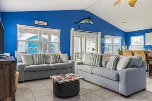 een woonkamer met 2 banken en blauwe muren bij Bikini Bottom in Gulf Shores