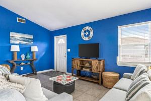 een woonkamer met blauwe muren en een flatscreen-tv bij Bikini Bottom in Gulf Shores