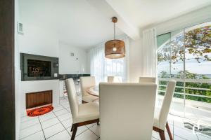 ein Esszimmer mit Tisch und Kamin in der Unterkunft Beira-mar em Canto Grande para 08 pessoas in Canto Grande + 30 Fotos