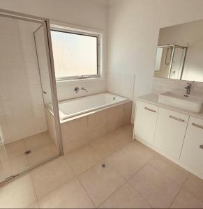 a bathroom with a bath tub and a sink at Sea Escape in Point Turton