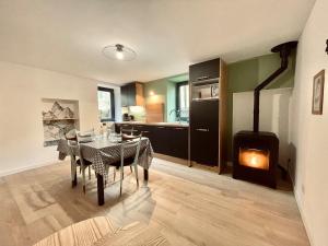 a kitchen and dining room with a table and a fireplace at La Petite Maison in Villargondran +12 photos