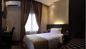 Rúm í herbergi á Mandarin Hotel Kota Kinabalu