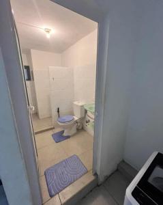 La salle de bains est pourvue de toilettes et d'un tapis bleu. dans l'établissement Evlogia, à Flic-en-Flac