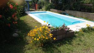 een zwembad met bloemen in een tuin bij Cabaña brisas del lago in Villa Parque Siquiman +7 foto's