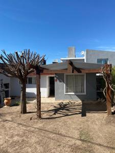 a house with a tree in front of it at Cabaña brisas del lago in Villa Parque Siquiman
