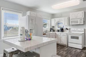 een keuken met witte apparaten en witte kasten bij Breaking Even in Gulf Shores +16 foto's