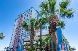 a tall building with palm trees in front of it at Palace Resort in Myrtle Beach