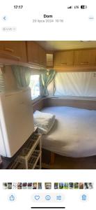 a small room with a bed and a laptop in it at Tififi przyczepa in Pobierowo
