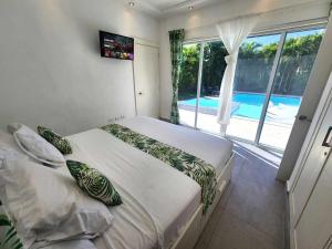 a bedroom with two beds and a large window at Unique 3 Bedrooms Villa las Palmas 41 in Puerto Plata +19 photos