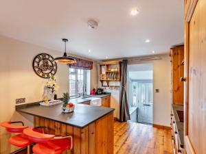 a kitchen with orange chairs and a large island at 2 Bed in Ilfracombe 81464 in Ilfracombe